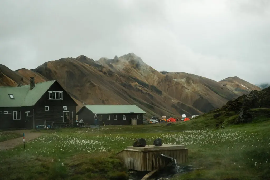 cabanes de montagne et tentes dans une vallée avec une source géothermale