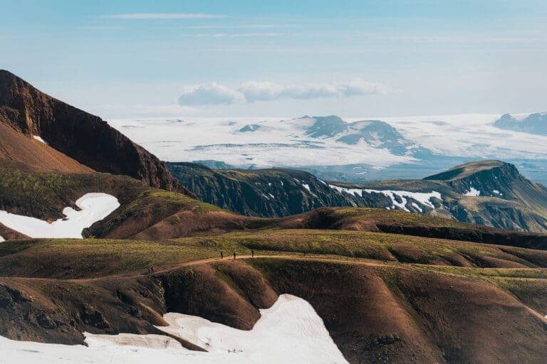 hikers on a trail in a vast Icelandic mountain landscape